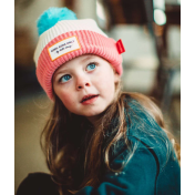petite fille avec bonnet rose et blanc avec super pompom bleu