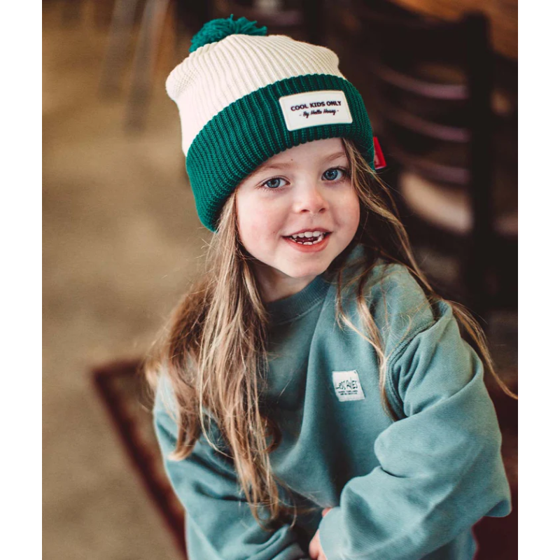 Petite fille avec bonne double polaire et pompom vert ultra tendance