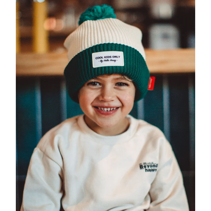 Enfant stylé grâce à son bonnet blanc et vert en coton bio de Hello Hossy